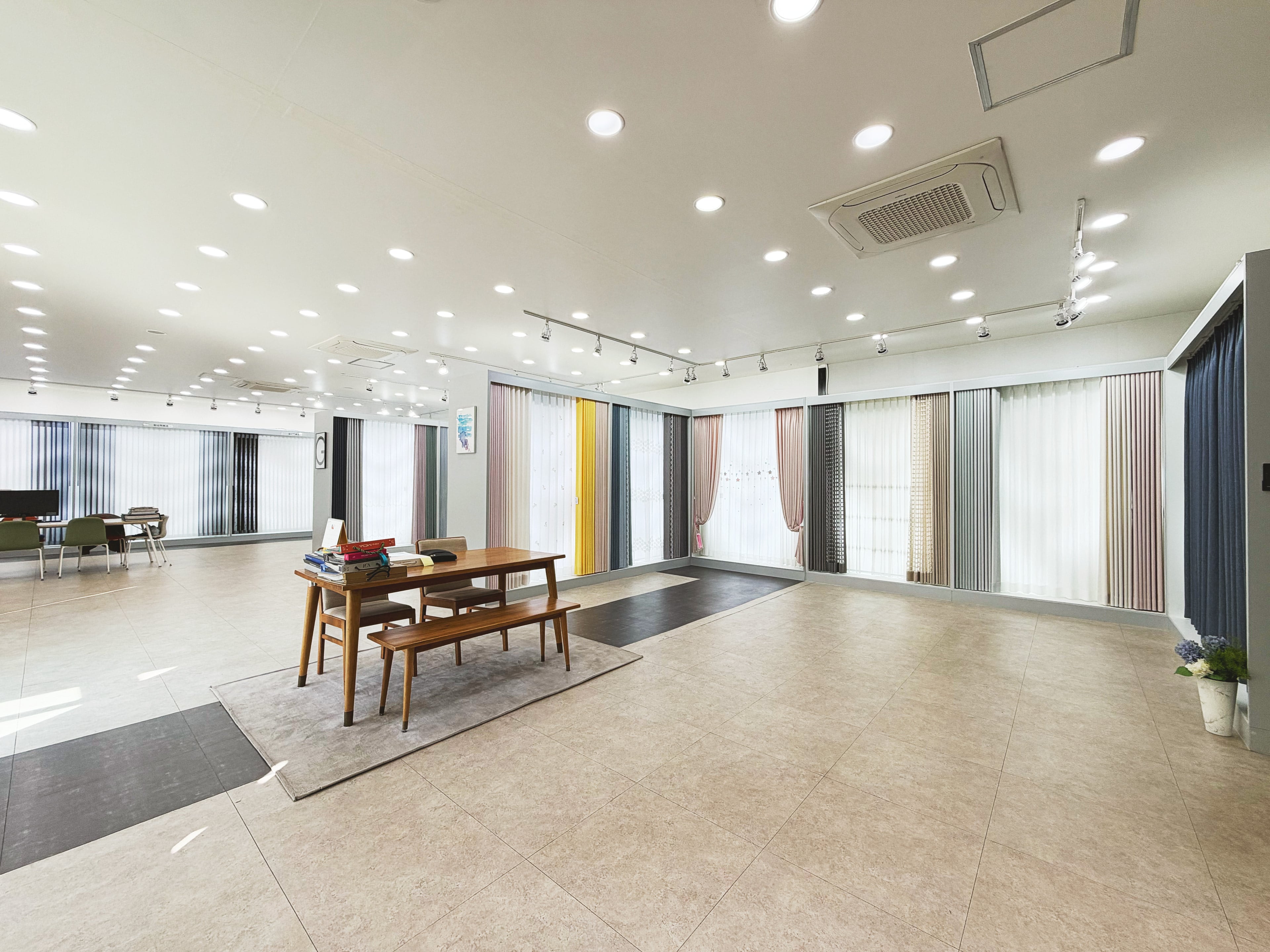 양주 전시장 내부, 넓은 바닥 너머로 커튼과 블라인드가 실제 창 크기로 줄지어 걸려 있는 모습